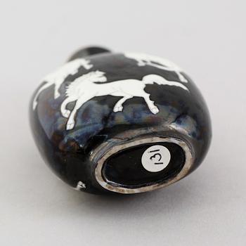 An enamelled porcelain snuff bottle with stopper, Qing dynasty (1644-1912).