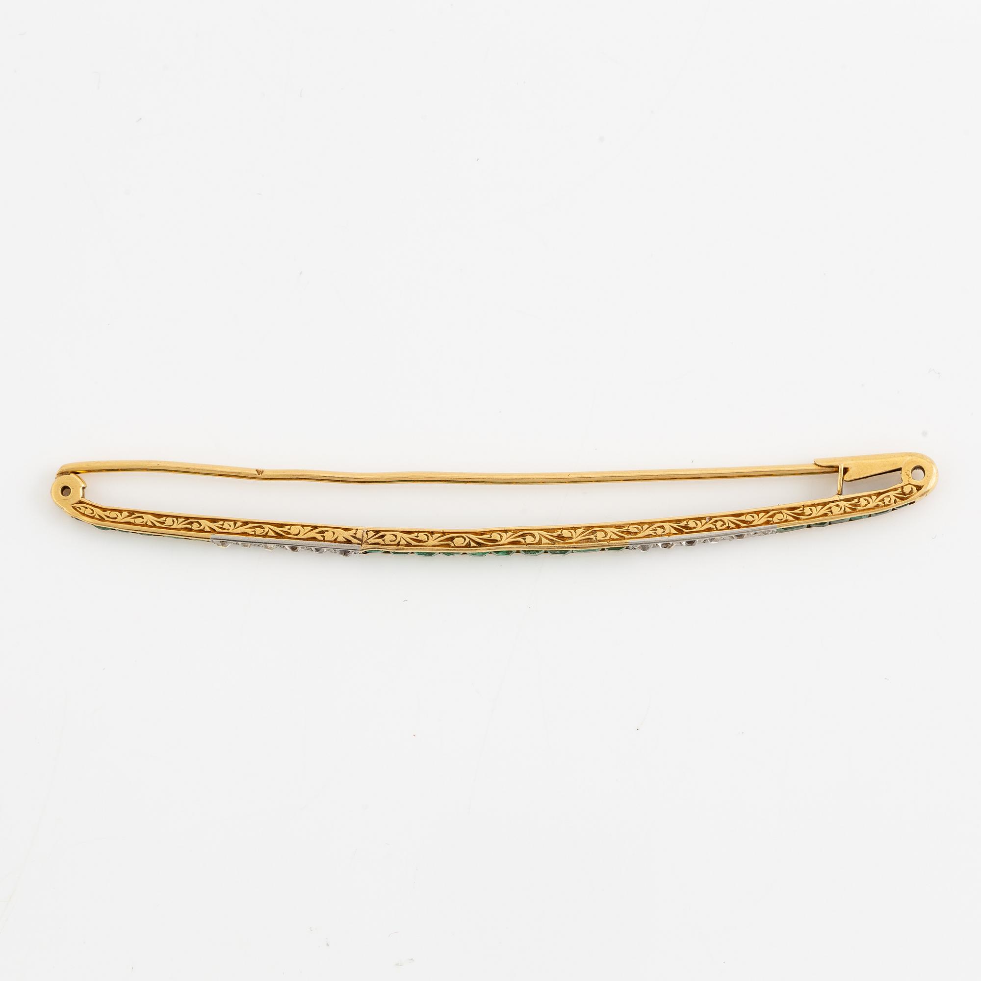 Brosch, längre modell, guld med carréslipade smaragder och gammalslipade diamanter, troligen omkring sekelskiftet 1900.
