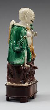 A green, yellow and brown glazed biscuit figure of Laughing boys, Qing dynasty, Kangxi (1662-1722).