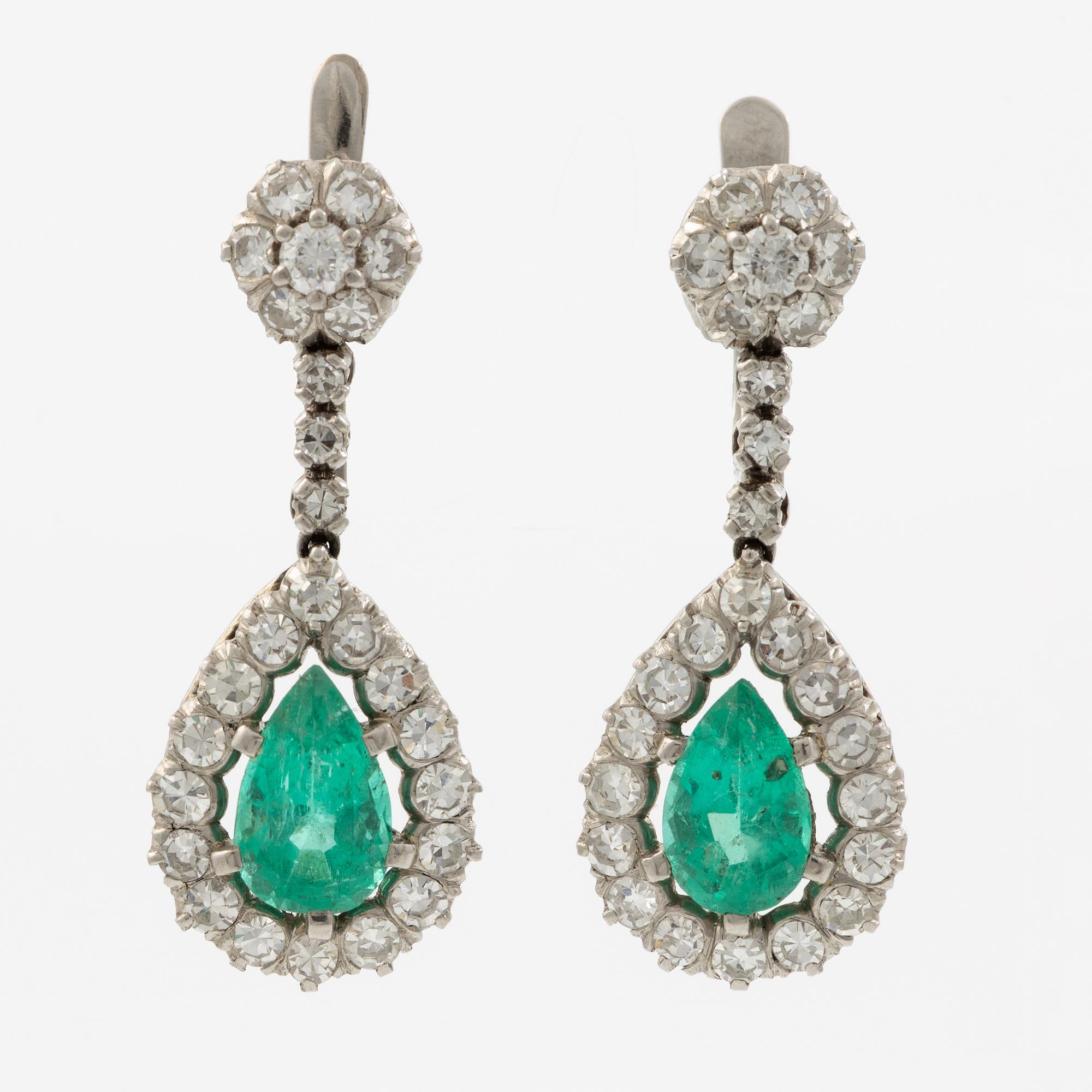 Earrings in platinum with drop-shaped emeralds and brilliant-cut and octagonal-cut diamonds.