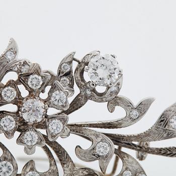 An 18K white gold brooch set with round brilliant-cut diamonds.