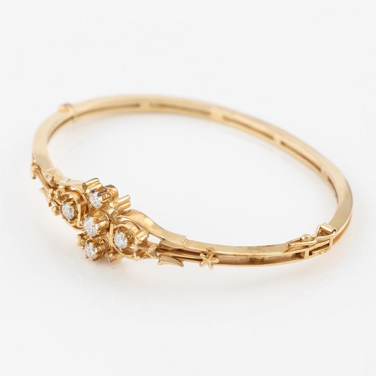 A bangle in 14K gold with round brilliant-cut diamonds.