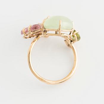 Ring with cabochon-cut prehnite, cut tourmaline in the shape of a butterfly, peridot, and brilliant-cut diamonds.