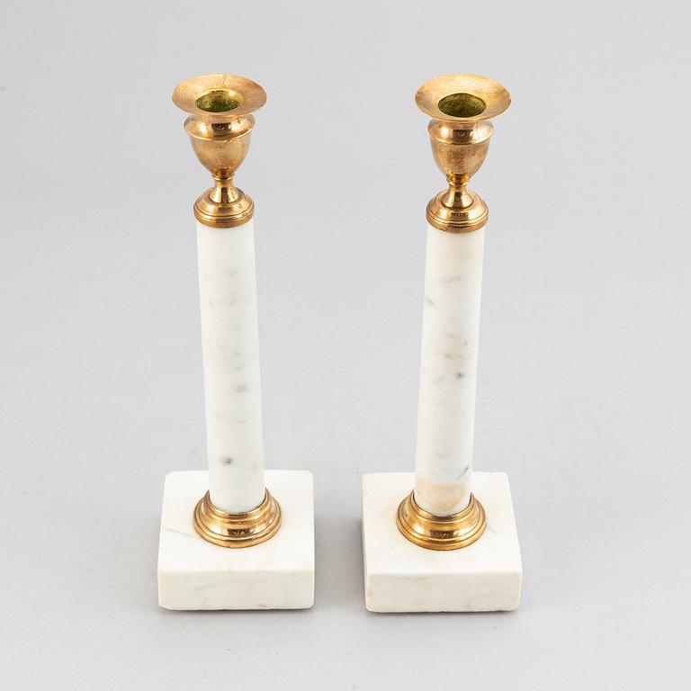 A pair of late Gustavian brass and cararra marble candle holders, around the year 1800.