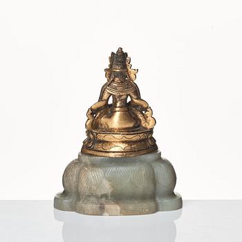 A gilt bronze figure of Amittayus seated on a later base of nephrite, Tibeto-Chinese, late 19th Century.