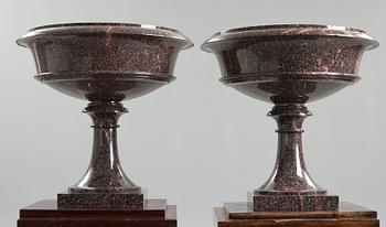 A pair of Swedish porpyry vases on wooden bases, Älvdalen, first half of the 19th century.