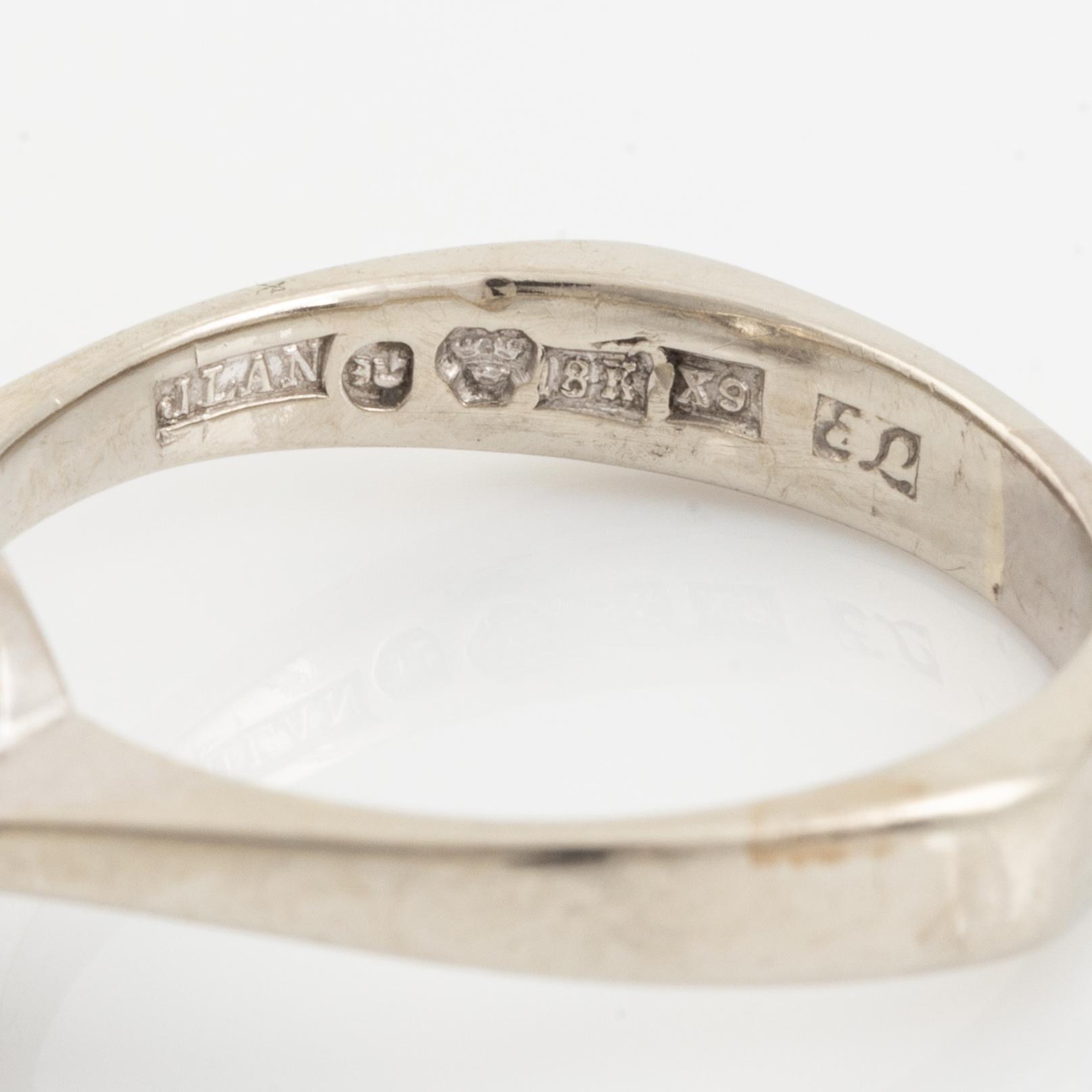 An 18K white gold ring set with a round brilliant-cut diamond.