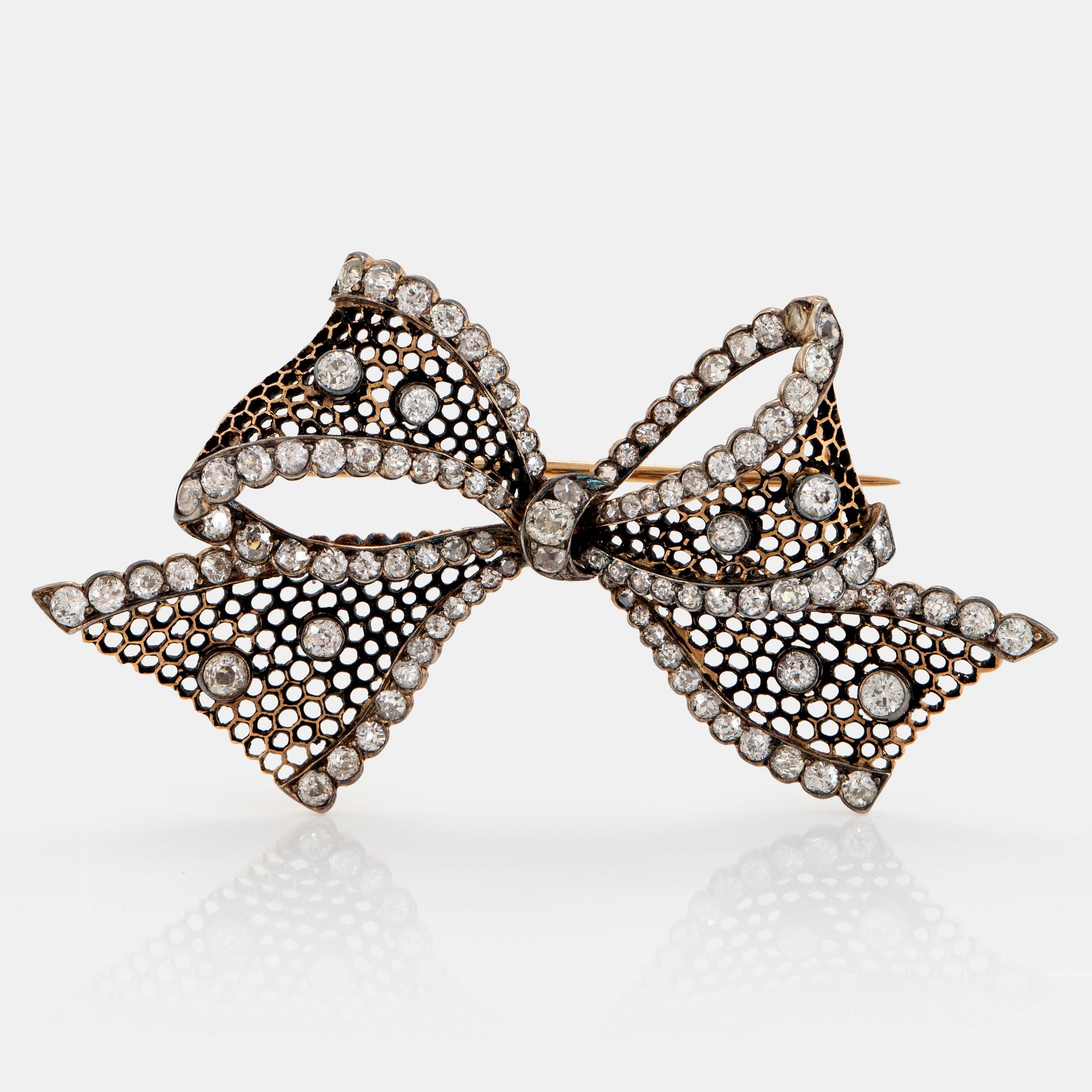 A 14K gold brooch set with old-cut diamonds.