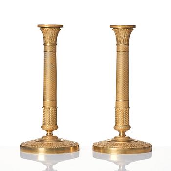 A pair of French Empire ormolu candlesticks, early 19th century.