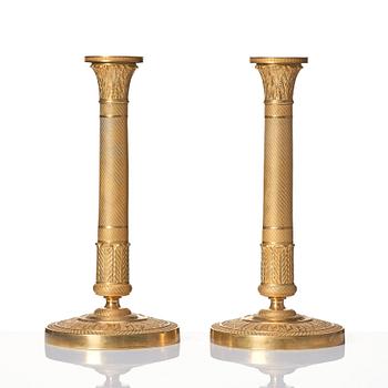 A pair of French Empire ormolu candlesticks, early 19th century.