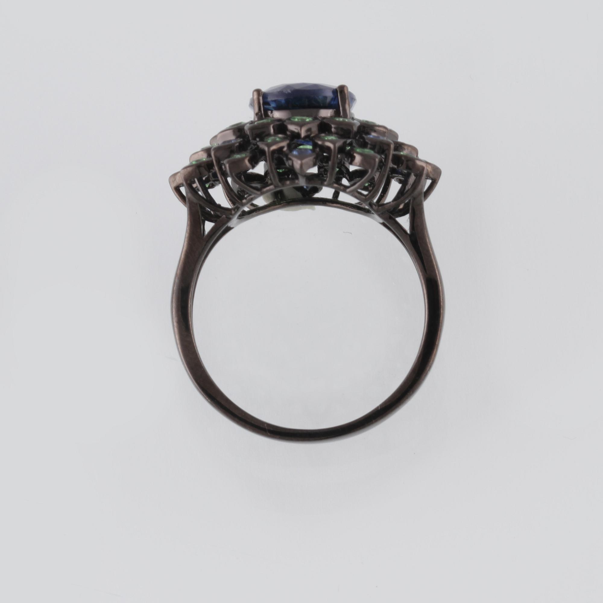 RING, 18K guld med fasettsliapde blå safirer ca 0.18 ct, kyanit ca 2.88 ct samt demantoider ca 0.60 ct. Vikt 6,2 gram.