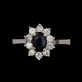 RING, 14k vitguld med safir och krans av 10 små diamant. Vikt ca 2,3 gram.