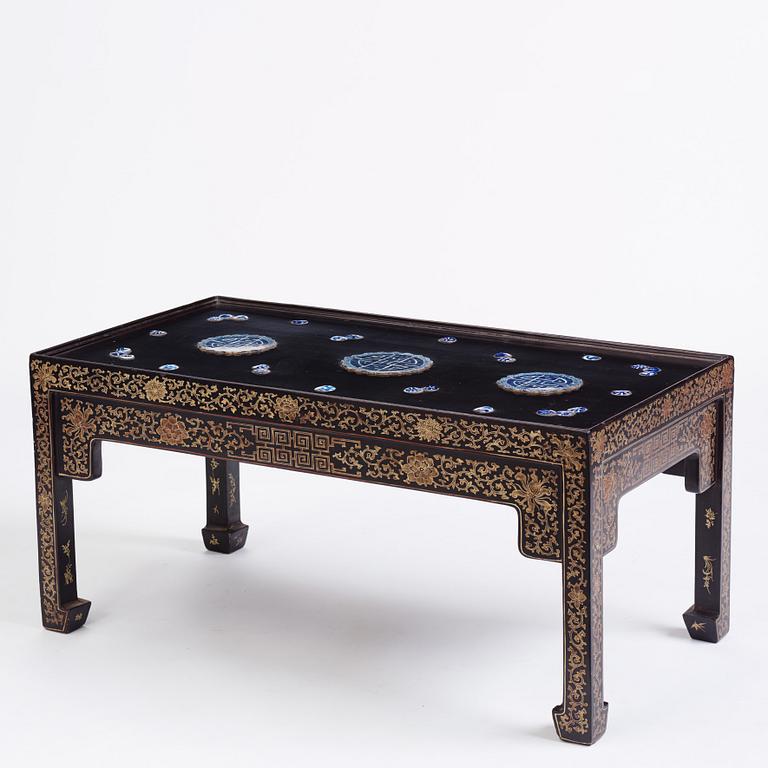 A Chinese black lacquered table with porcelain placques, presumably first half of the 20th century.