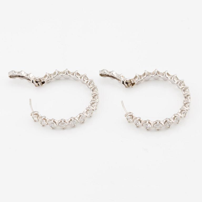 A pair of earrings in 18K white gold set with round brilliant-cut diamonds.