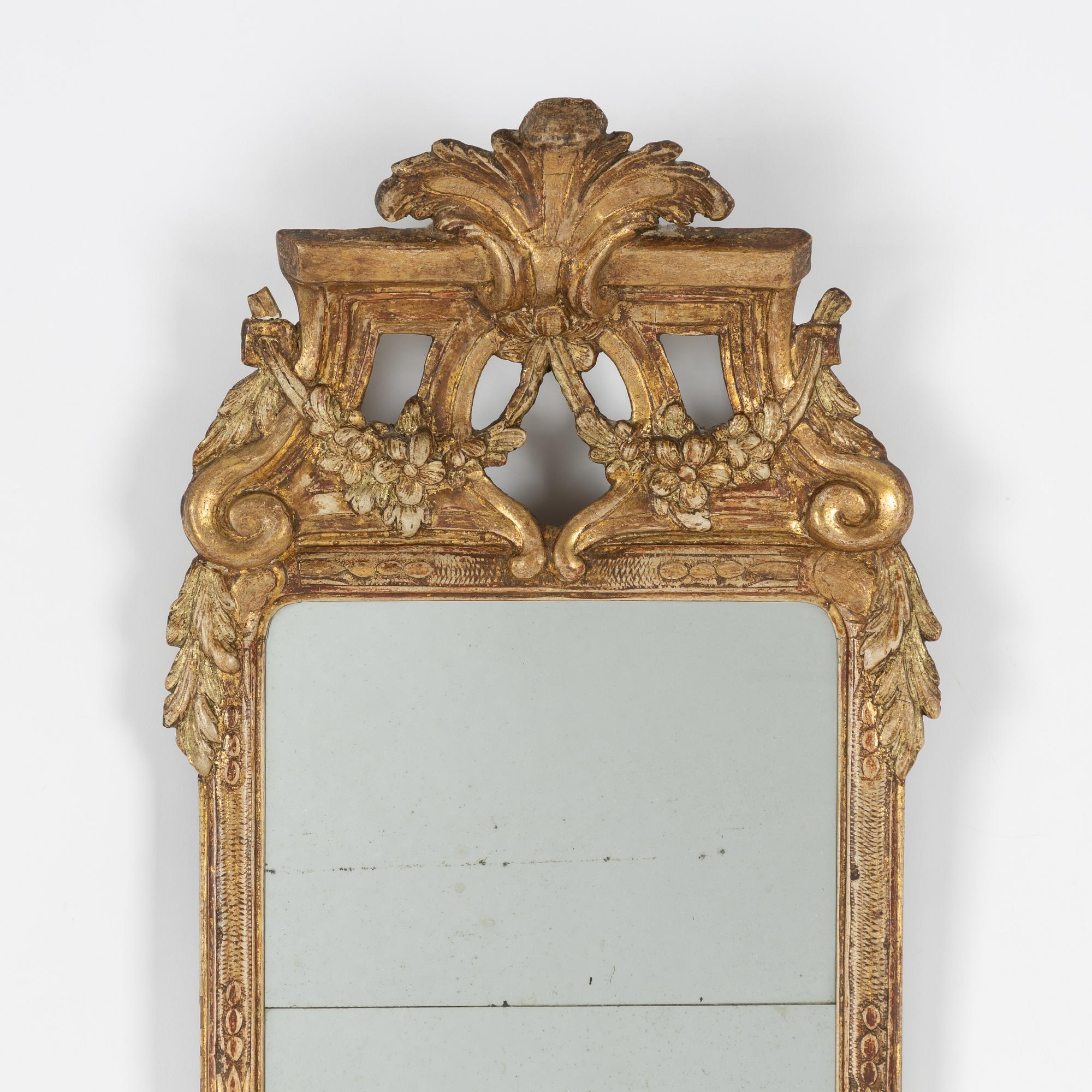 A Gustavian carved giltwood mirror, Stockholm, late 18th century.