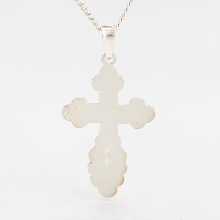 A stelring silver necklace with a cross.
