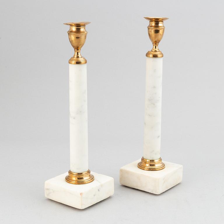 A pair of late Gustavian brass and cararra marble candle holders, around the year 1800.