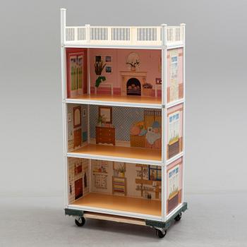 A plastic doll's house with six dolls, furniture and clothes, 20th century.