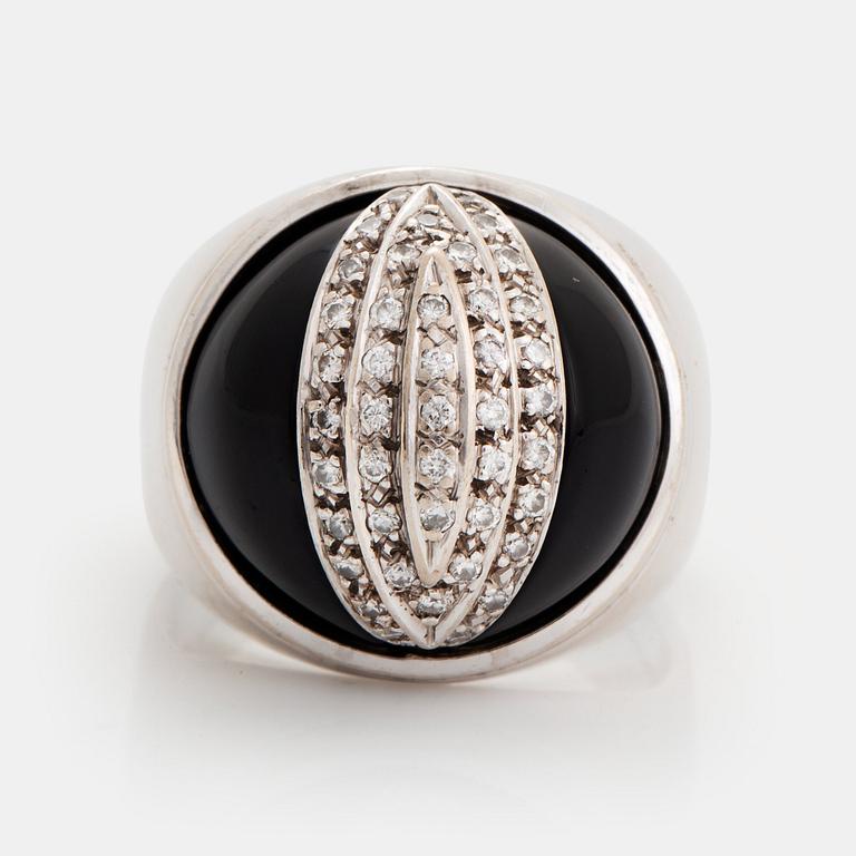 An 18K white gold and onyx ring set with round brilliant-cut diamonds.