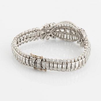 A platinum bracelet set with step-cut and brilliant-cut diamonds.