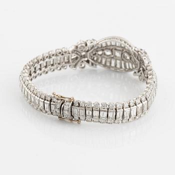 A platinum bracelet set with step-cut and brilliant-cut diamonds.