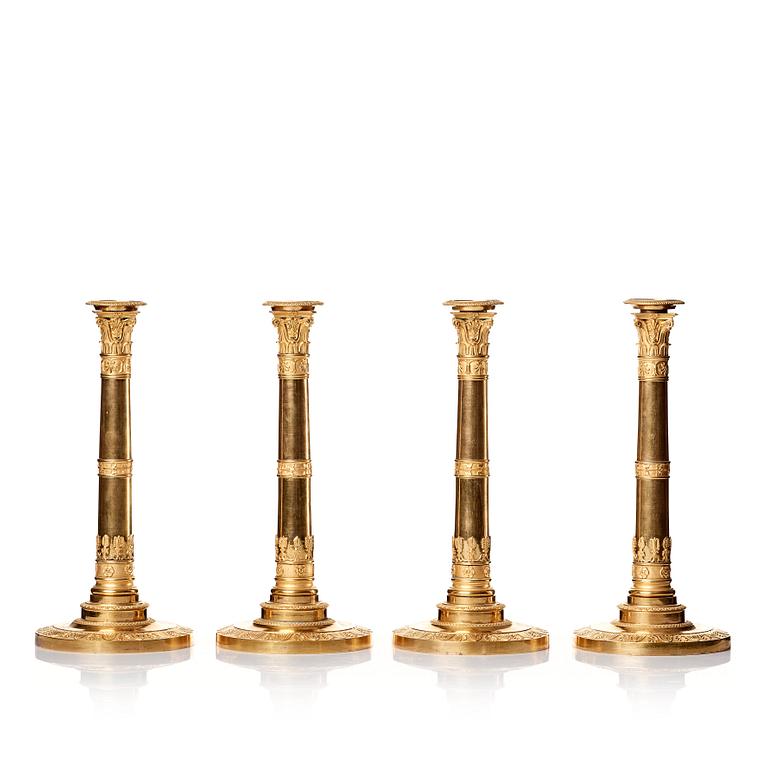 A set of four Empire presumably Russian candlesticks in gilded bronze.