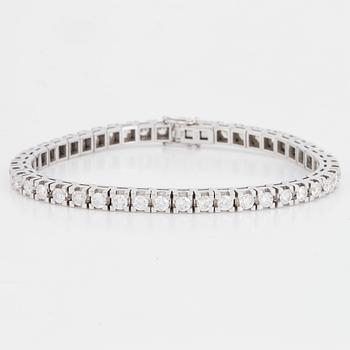 An 18K white gold tennisbraclet set with round brilliant-cut diamonds.