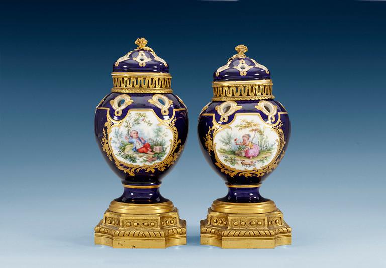 A pair of gilt bronze mounted Sevres pot-pourri jars with covers, 18th Century. (2).