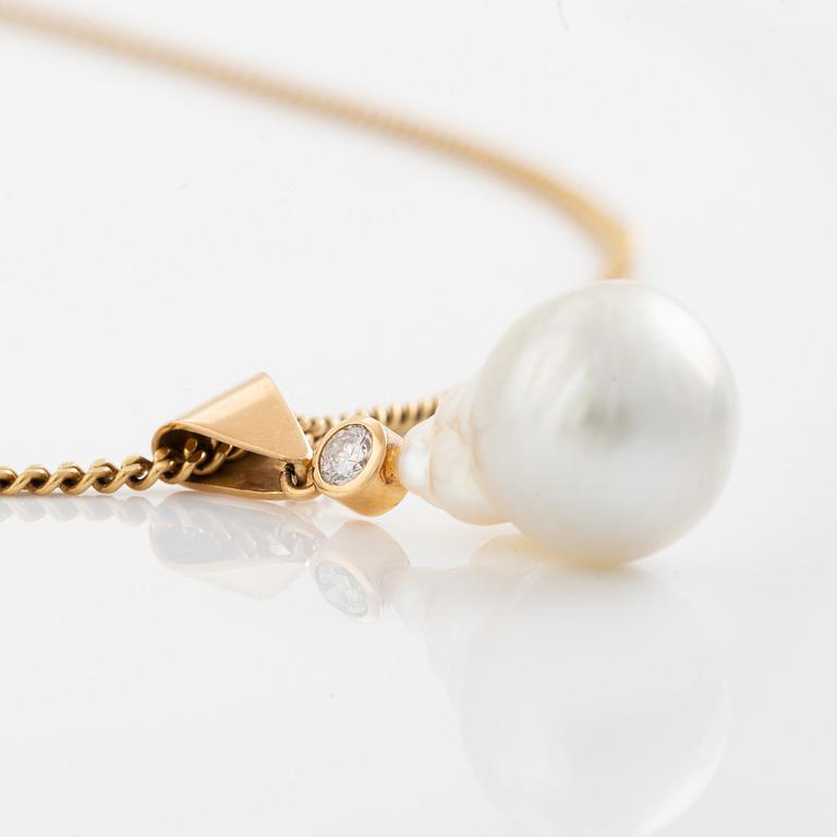 An 18K gold and cultured pearl pendant set with a round brilliant-cut diamond.