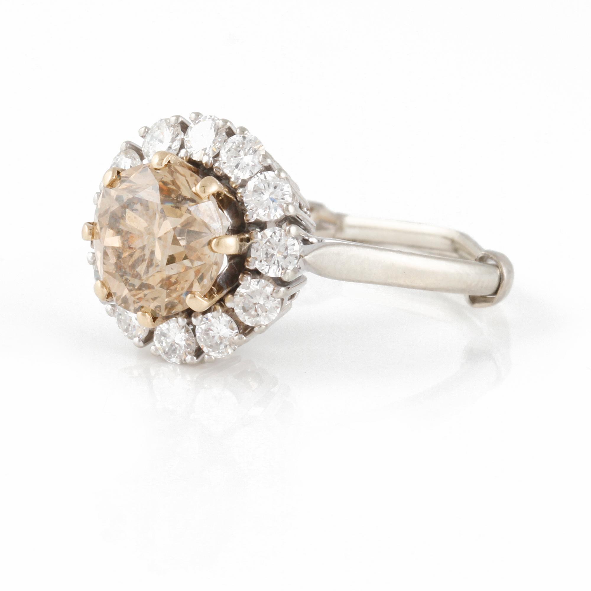 RING, med briljantslipad brun diamant ca 1.60 ct med krans av 11 små vita briljantslipade diamanter totalt ca 0.55 ct.