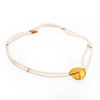 A necklace of cultured pearls and pendant in 18K gold with a brilliant cut diamond.