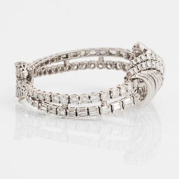 A platinum bracelet set with round brilliant- and baguette-cut diamonds.