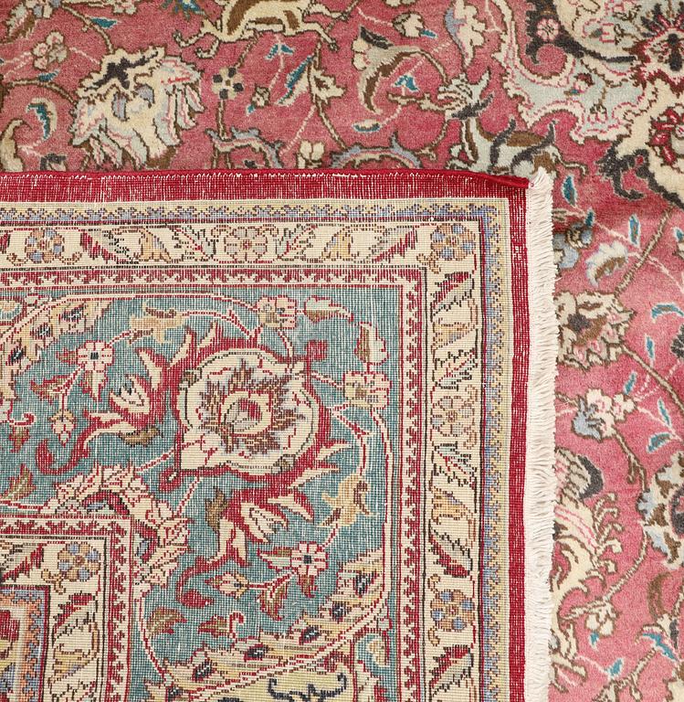 A Tabriz carpet, signed, c. 395 x 298 cm.