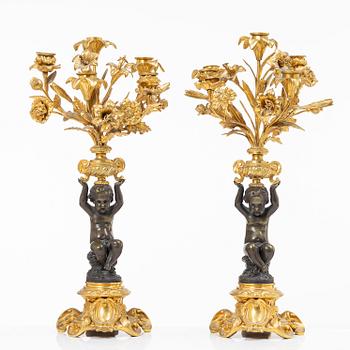 A Rococo style mantle clock and pair of candelabra, France, late 19th Century.
