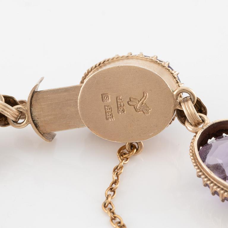 A set with a necklace, a bracelet, a brooch, and a ring.