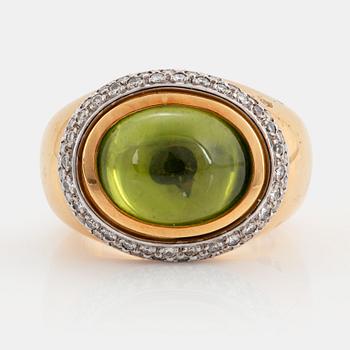 An 18K gold Steinlin ring set with a cabochon-cut peridot and round brilliant-cut diamonds.