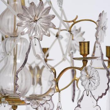 A near pair of rococo-style gilt brass and cut glass six-branch chandeliers, 19th century incorporating older elements.