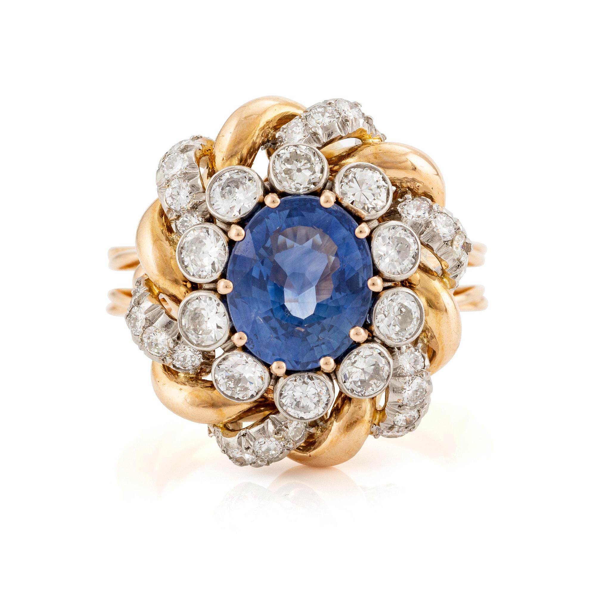An 18K gold  ring with a sapphire and round brilliant-cut diamonds.