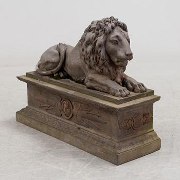 A SCULPTURE/ DECOR-ELEMENT, a lion on a plint, artificial stone, empire-style, late 1900s.