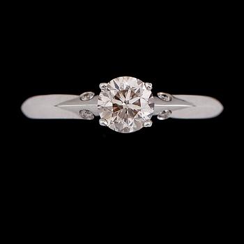 RING, 18 k vitguld, solitär briljantslipad diamant ca 0.71 ct, 4 mindre briljantslipade diamanter tot ca 0.03 ct.