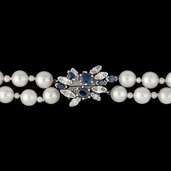 1225. A two strand cultured pearl necklace, 6,8 mm, with blue sapphire and diamond clasp.