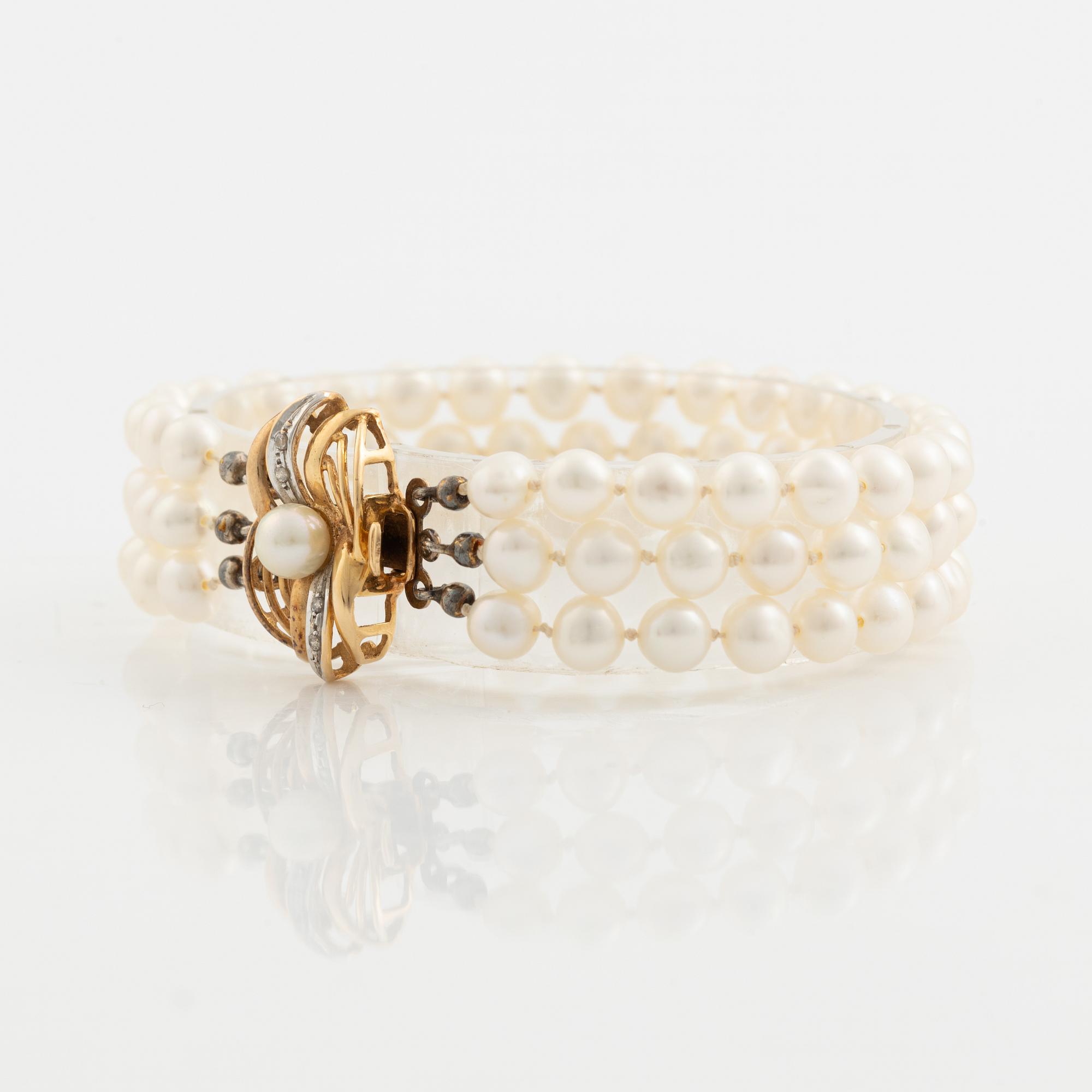 Bracelet, three-stranded with cultured pearls, clasp with a pearl and small diamonds.