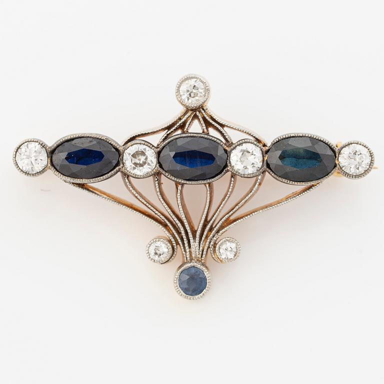 Brooch 18K gold and platinum set with step-cut sapphires and round brilliant-cut diamonds.