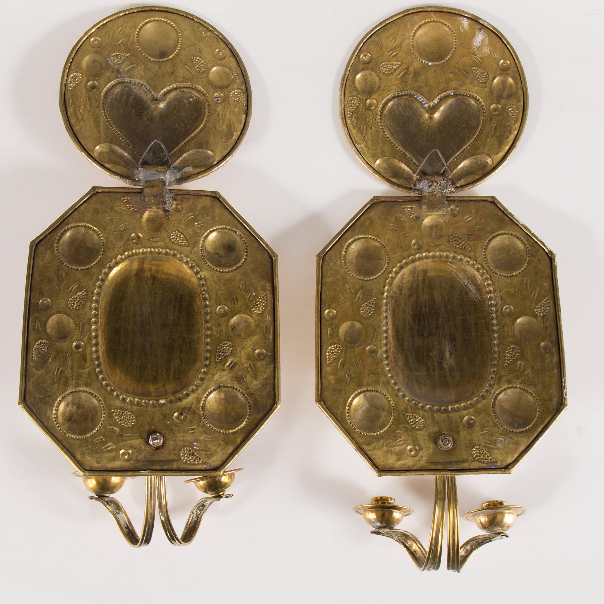 A pair of first half of the 20th century brass two-light wall sconces.