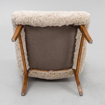 A mid 20th Century easy chair with sheepskin upholstery.
