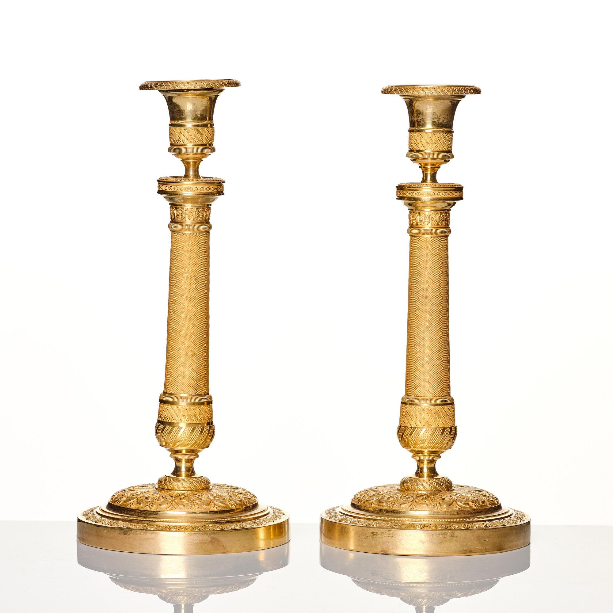 A pair of French gilded Empire candlesticks, early 19th century.