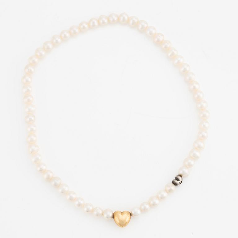 Ole Lynggaard 18K gold clasp in the shape of a heart with a cultured freshwater pearl necklace with a silver heart.