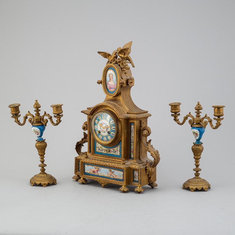 A table clock and two candelabras from the late 19th century.