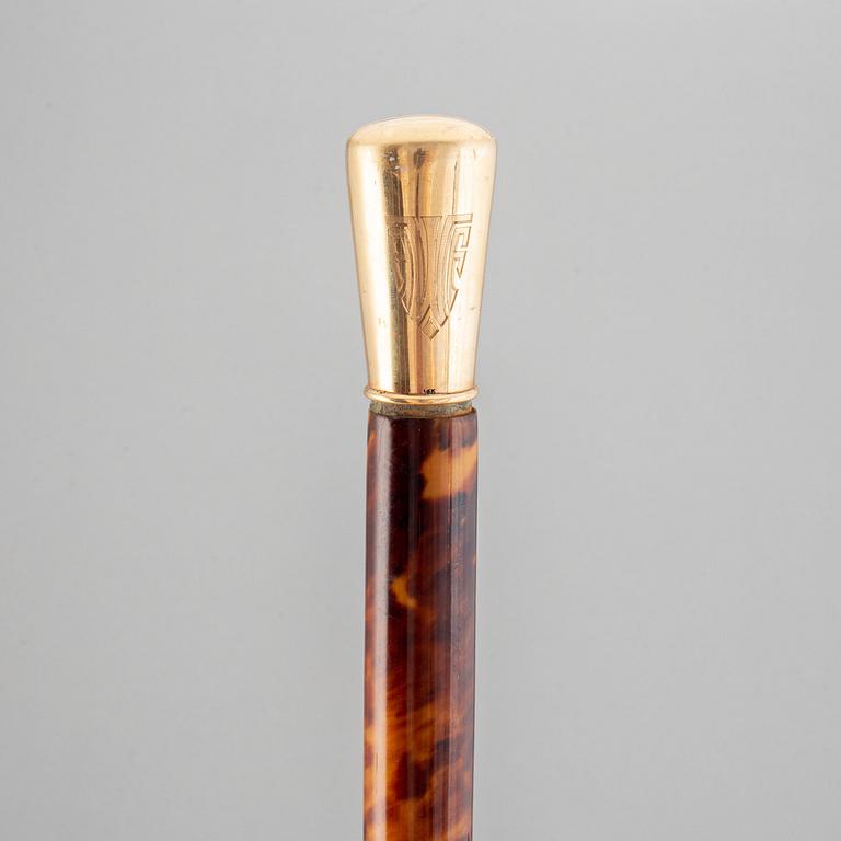 A tortoise imitation veneer, bone, and 14 ct gold walking stick.