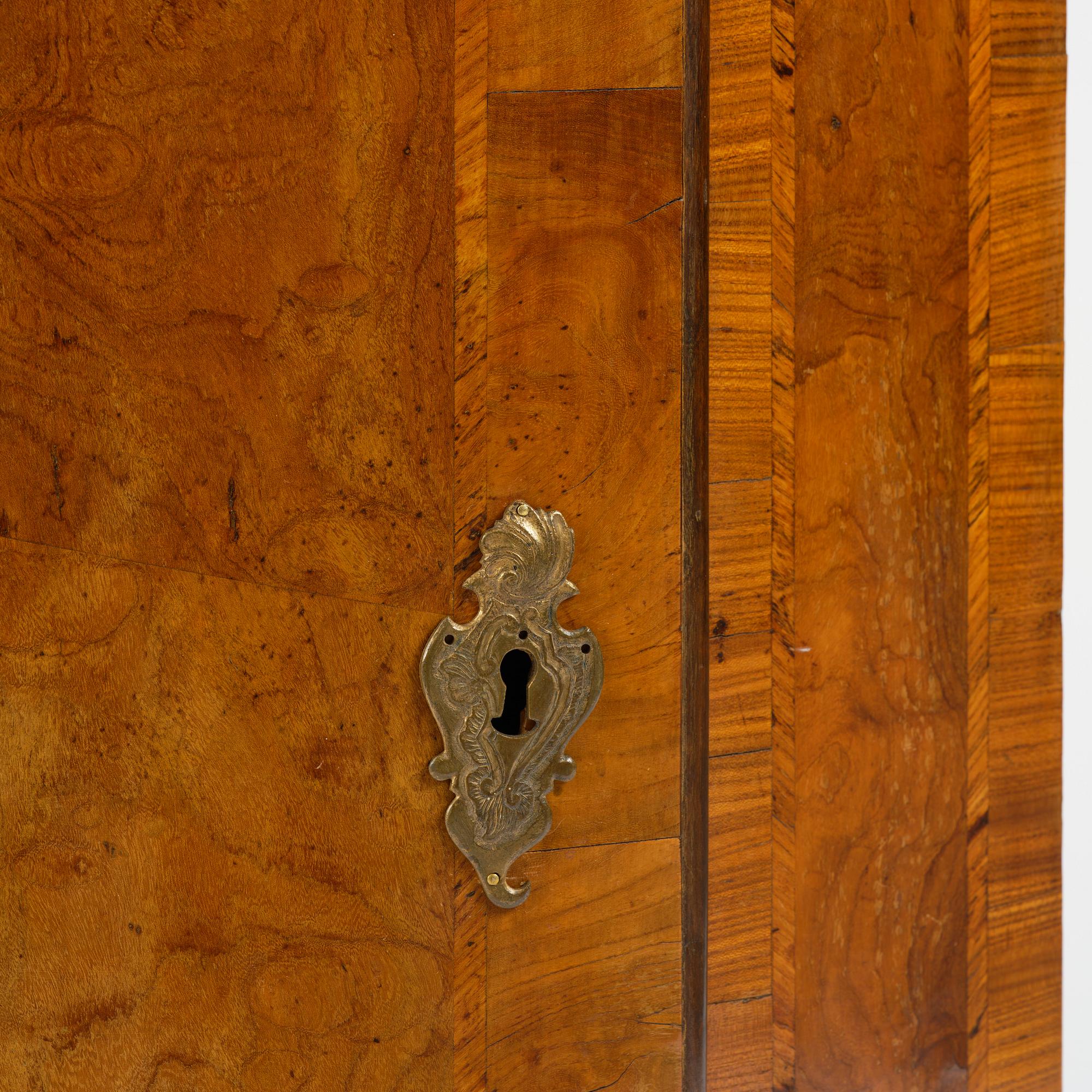 A Swedish late baroqu elm-veneered corner hanging cabinet. first part 18th century.